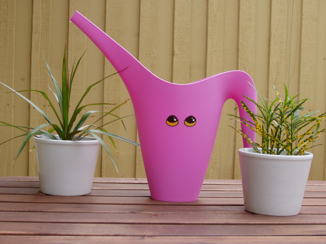 A bubblegum pink pitcher with bright yellow cartoon eyes on it.