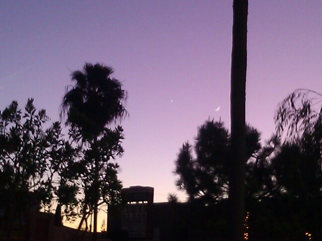 New moon and Venus against a purple sky.