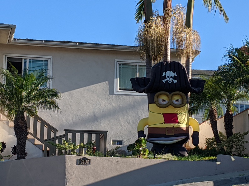 Giant inflatable Minion decoration in front of a house...with a face mask added.